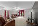 Large living room with comfortable seating, a ceiling fan, and natural light from windows with red curtains at 5805 Laurel Rock Ln, Raleigh, NC 27613