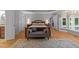 Spacious main bedroom with hardwood floors, tray ceiling, large window, and seating area at 5805 Laurel Rock Ln, Raleigh, NC 27613