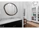 Elegant powder room with dark vanity, marble countertop, round mirror, and hardwood flooring at 620 Wade Ave # 505, Raleigh, NC 27605