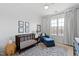 Cozy Bedroom with dark wood crib, blue chair, neutral rug, and soft natural light at 620 Wade Ave # 505, Raleigh, NC 27605