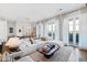 Bright living room with a large white sectional sofa, elegant curtains, and balcony access at 620 Wade Ave # 505, Raleigh, NC 27605