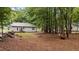 View of a backyard with mature trees and a neighboring house at 627 Gaslight Trl, Wendell, NC 27591