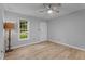 Bedroom with neutral walls, wood-look flooring, a ceiling fan, and a window offering natural light at 627 Gaslight Trl, Wendell, NC 27591