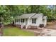 Cozy one-story home with light siding, black shutters, and a welcoming front porch, set amidst a green lawn and trees at 627 Gaslight Trl, Wendell, NC 27591
