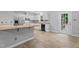 Clean kitchen with white cabinets, a breakfast bar, stainless steel refrigerator, and black dishwasher with wood floors at 627 Gaslight Trl, Wendell, NC 27591