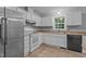 Bright kitchen featuring white cabinetry, laminate countertops, stainless steel refrigerator, and wood-look flooring at 627 Gaslight Trl, Wendell, NC 27591