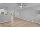 Open-concept living space with neutral walls, wood-look flooring, and a ceiling fan, connecting to the kitchen at 627 Gaslight Trl, Wendell, NC 27591