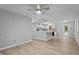 Open-concept living space with neutral walls, wood-look flooring, a ceiling fan, and open access to the kitchen at 627 Gaslight Trl, Wendell, NC 27591
