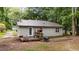 View of the rear exterior with trees, siding, roof, and a small back deck at 627 Gaslight Trl, Wendell, NC 27591
