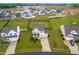 Beautiful aerial shot of a two story home with a manicured lawn and a long driveway, set in a vibrant community at 66 Arlie Ln, Lillington, NC 27546