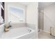 Bright bathroom featuring a soaking tub, separate glass shower, and window at 66 Arlie Ln, Lillington, NC 27546