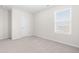 Clean and bright bedroom with a window, neutral carpet, and white door at 66 Arlie Ln, Lillington, NC 27546