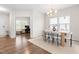 Bright dining area featuring a modern chandelier, wood table, and views into the bright office space at 66 Arlie Ln, Lillington, NC 27546