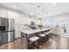 Well-lit kitchen with a large island, stainless steel appliances, white cabinets, and modern pendant lighting at 66 Arlie Ln, Lillington, NC 27546
