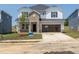Two-story home boasts a brick-accented entrance, attached garage, and a beautifully landscaped front yard at 667 White Birch Ln, Angier, NC 27501