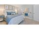 Cozy bedroom featuring a comfortable bed with blue accents, soft lighting, and a wall mirror at 673 Sun Meadow Dr, Wake Forest, NC 27587