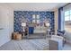 Bright Bedroom with patterned wallpaper, a crib, and a comfortable chair at 673 Sun Meadow Dr, Wake Forest, NC 27587