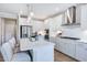 Stylish kitchen boasts white cabinets, stainless appliances, island, and modern pendant lights at 673 Sun Meadow Dr, Wake Forest, NC 27587