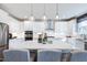 Open kitchen featuring white cabinets, stainless appliances, quartz countertops, and a central island with seating at 673 Sun Meadow Dr, Wake Forest, NC 27587