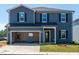Two-story home featuring blue siding, black shutters, and an attached two-car garage at 722 White Birch Ln, Angier, NC 27501