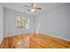 Light-filled bedroom with hardwood floors, ceiling fan, and a large window offering natural light at 8231 Allyns Landing Way # 101, Raleigh, NC 27615