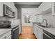 Bright kitchen featuring stainless steel appliances, granite countertops, and wood flooring at 8231 Allyns Landing Way # 101, Raleigh, NC 27615