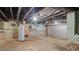 Unfinished basement with exposed beams, pipes, and concrete floors at 830 S Chestnut St, Henderson, NC 27536