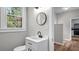 Bright bathroom features a modern sink, stylish mirror, and an open doorway, offering a clean and inviting space at 830 S Chestnut St, Henderson, NC 27536