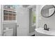 Well-lit bathroom featuring a circular mirror and pedestal sink at 830 S Chestnut St, Henderson, NC 27536