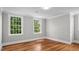 Spacious bedroom with hardwood floors and large windows that provide plenty of natural light, creating a welcoming atmosphere at 830 S Chestnut St, Henderson, NC 27536