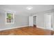 Hardwood floors and natural light flood this bedroom with an open door, creating a bright and welcoming ambiance at 830 S Chestnut St, Henderson, NC 27536