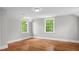 Bright bedroom featuring hardwood floors, complemented by two large windows that fill the space with natural light at 830 S Chestnut St, Henderson, NC 27536