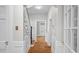 Hallway with hardwood floors and white trim provides a bright path to multiple rooms at 830 S Chestnut St, Henderson, NC 27536