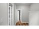 Hallway with white trim and wood-look floors leads to various rooms and transitions to the bath at 830 S Chestnut St, Henderson, NC 27536