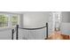 Bright upstairs landing featuring wood floors, a half-wall, and a bathroom at 830 S Chestnut St, Henderson, NC 27536