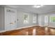 Bright living room features hardwood floors, neutral paint and double doors to outside at 830 S Chestnut St, Henderson, NC 27536
