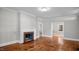 Cozy living room featuring a fireplace with brick hearth and hardwood flooring at 830 S Chestnut St, Henderson, NC 27536