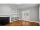 Bright living room boasts a fireplace and built-in shelving with glass doors leading to the outdoors at 830 S Chestnut St, Henderson, NC 27536