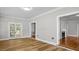 Bright living room featuring hardwood floors, neutral walls, and french doors leading to the backyard at 830 S Chestnut St, Henderson, NC 27536