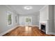 Bright living room featuring hardwood floors, a fireplace, and double doors to outside at 830 S Chestnut St, Henderson, NC 27536