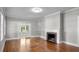 Bright living room featuring hardwood floors, a fireplace, and double doors to outside at 830 S Chestnut St, Henderson, NC 27536