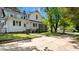 Rear view of home with screened in porch, white siding, and a spacious driveway at 830 S Chestnut St, Henderson, NC 27536