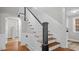 Classic staircase with dark accents, white wainscoting, and wood stairs at 830 S Chestnut St, Henderson, NC 27536