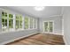 Bright sunroom features plank flooring and many windows offering natural light at 830 S Chestnut St, Henderson, NC 27536