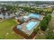Aerial view of a community pool with a playground, lounge areas, and lush landscaping in a residential area at 850 Apalachia Lake Dr, Fuquay Varina, NC 27526