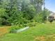 A backyard garden featuring metal raised beds with a grassy lawn that leads to a home's exterior at 850 Apalachia Lake Dr, Fuquay Varina, NC 27526