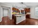 This kitchen features custom cabinets, stainless steel appliances, a granite island, and beautiful hardwood floors at 850 Apalachia Lake Dr, Fuquay Varina, NC 27526