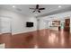 Spacious living room features hardwood floors, a ceiling fan, neutral paint, and seamless access to the kitchen area at 850 Apalachia Lake Dr, Fuquay Varina, NC 27526
