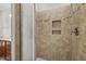 Walk-in shower features tiled walls, built-in shelving, and a glass shower door at 850 Apalachia Lake Dr, Fuquay Varina, NC 27526