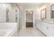 Bright bathroom with glass enclosed shower, double vanity, and view to main bedroom at 90 Starwood Dr, Garner, NC 27529